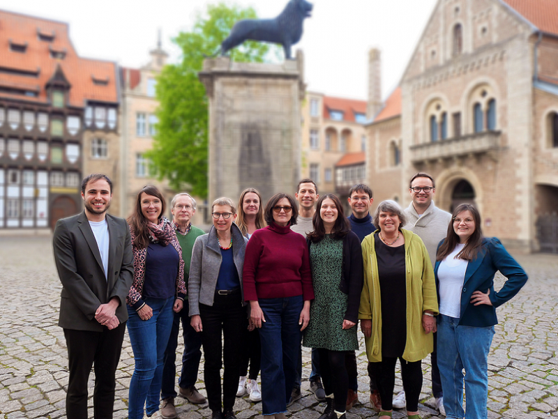 Gruppenfoto der Grünen Ratsfraktion Braunschweig, aufgenommen auf dem Burgplatz mit dem Braunschweiger Löwen im Hintergrund.